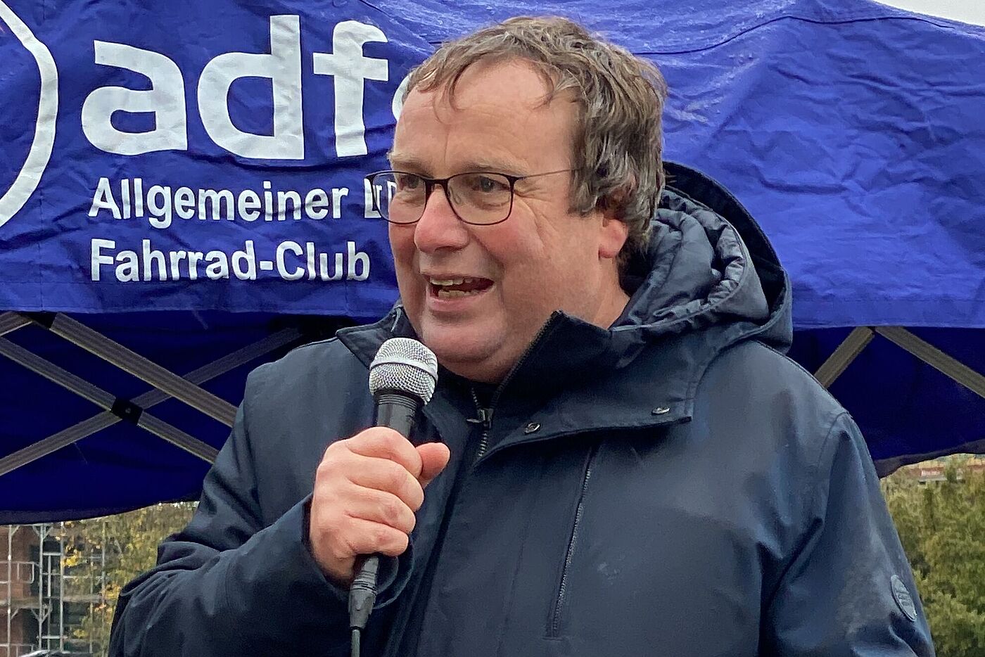 NRW-Verkehrsminister Oliver Krischer vor blauem Pavillion des ADFC NRW