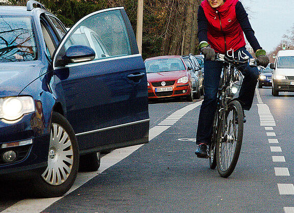 Auto Tür geöffnet, Radfahrerin weicht in Kfz Verkehr aus. 