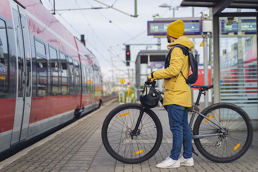 Fahrradmitnahme beim Deutschlandticket Ein Radfahrer steht mit seinem Fahrrad auf einem Bahnsteig.