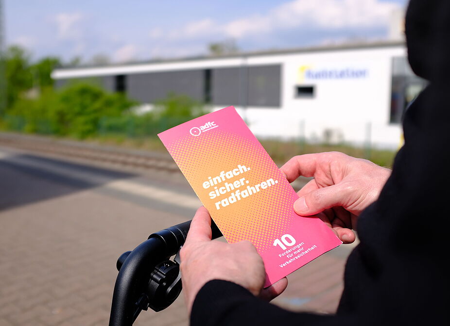 2026-04-17_Dormagen_Verkehrssicherheit__ADFC_NRW Eine Person hält einen Flyer in den Händen.
