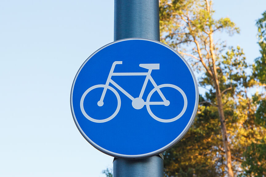 NRW braucht mehr Fachkräfte für Bau und Planung von Radverkehrsinfrastruktur. Ein blaues Schild mit einem Fahrradsymbol, das einen benutzungspflichtigen Radweg anzeigt.