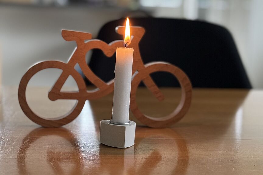 Schweigeminute am 11.02.2024 um 13 Uhr für den Blogger #Natenom und alle im Straßenverkehr schwer verletzten und getöteten Radfahrerinnen und Radfahrer Foto zur Schweigeminute für #Natenom brennende Kerze vor Miniatur-Fahrrad aus Holz