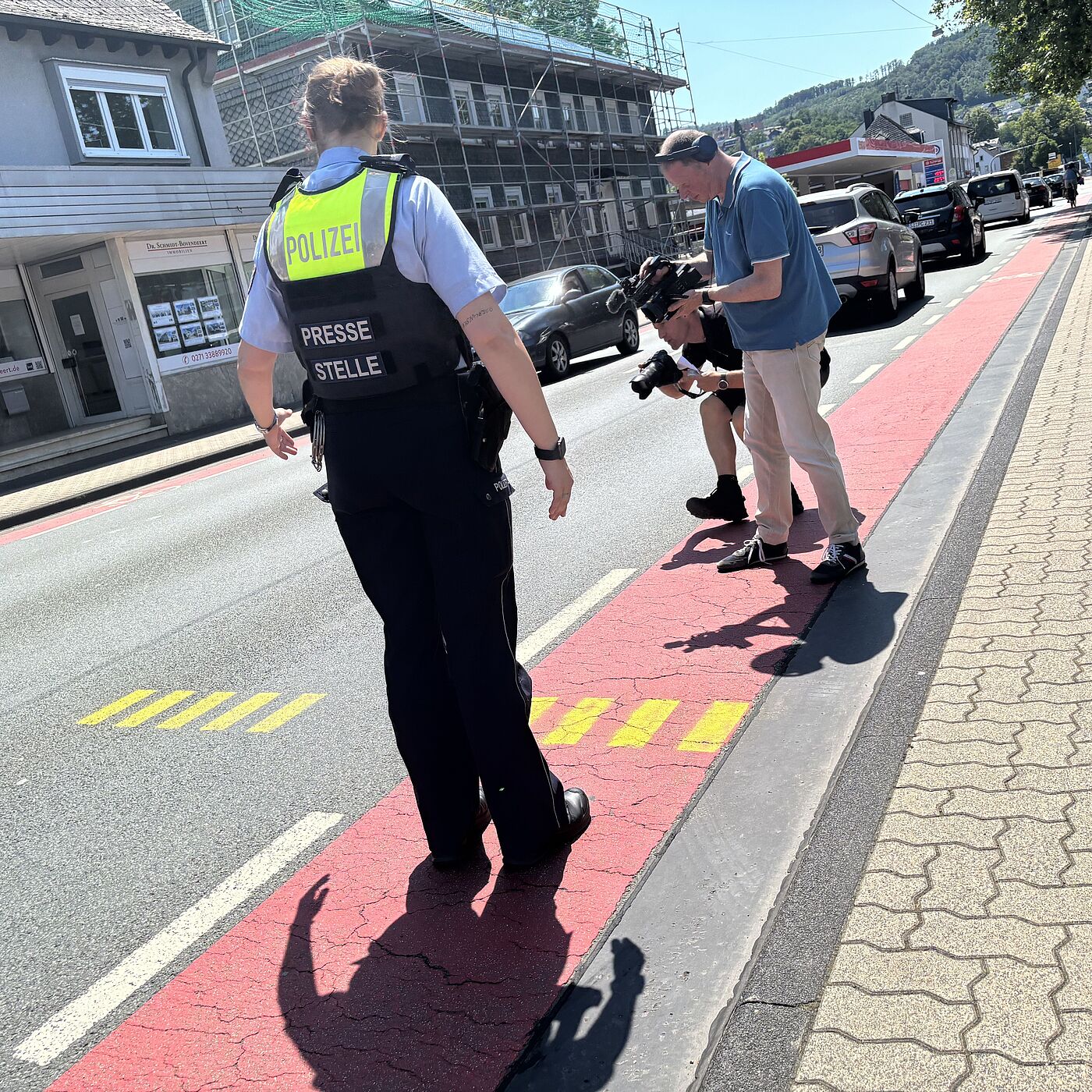 Die Sprecherin Frau Teichmann der Polizei Siegen-Wittgenstein erläutert eine Hilfsmarkierung zum Messen des Überholabstandes.