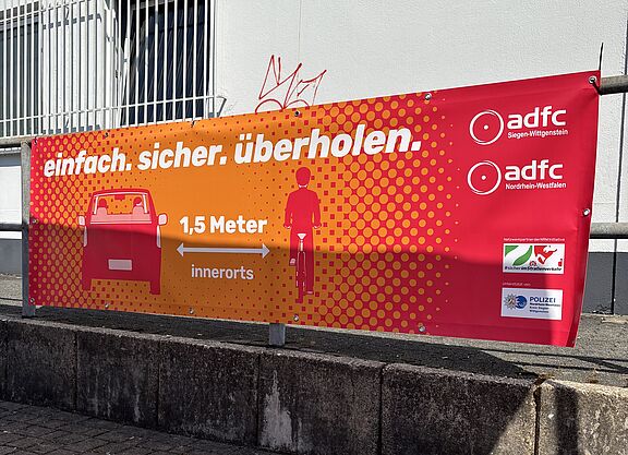 Brückenbanner einfach. sicher. überholen. Ein Banner weist auf den gesetzlich vorgeschriebenen Überholabstand von 1,5 Metern innerorts hin.