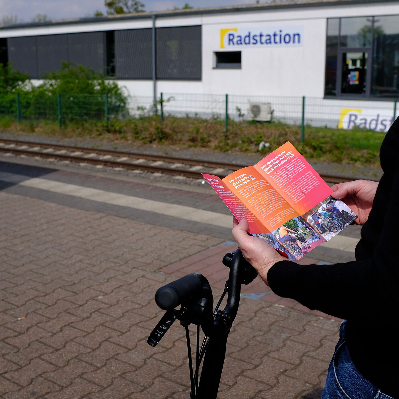 Eine Person hält den Flyer in der Hand. 