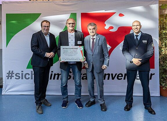 Die Beitrittsurkunde wird von NRW-Innenminister Herbert Reul und NRW-Verkehrsminister Oliver Krischer an ADFC NRW-Vorstandsmitglied Jürgen Heidenreich übergeben.