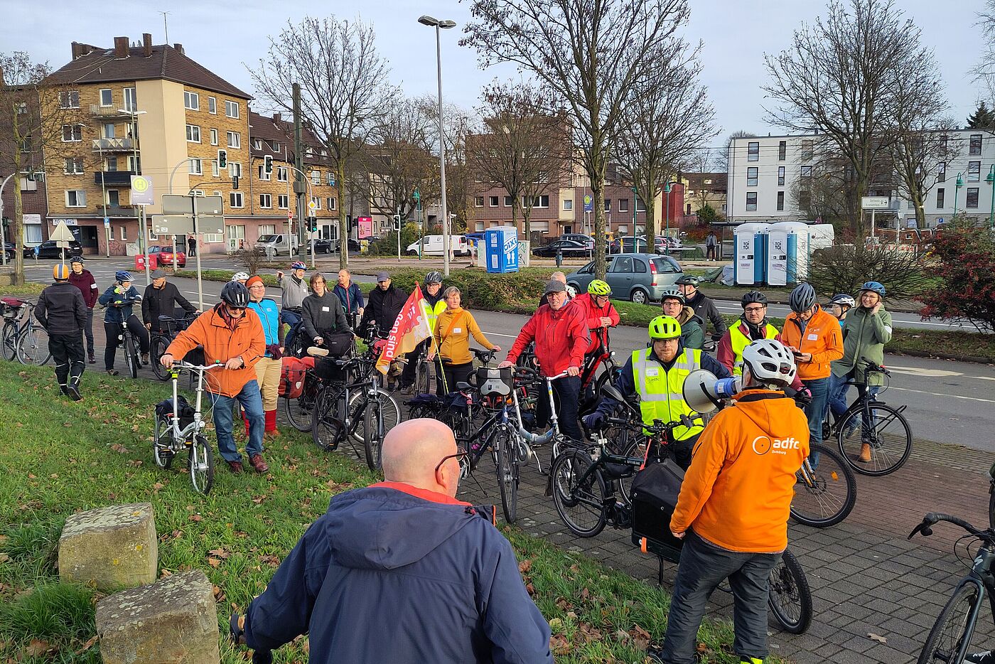 Mehrere Menschen auf dem Rad stehen auf einem Gehweg in Duisburg.