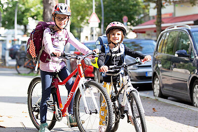 Mädchen mit Ranzen auf dem Fahrrad.