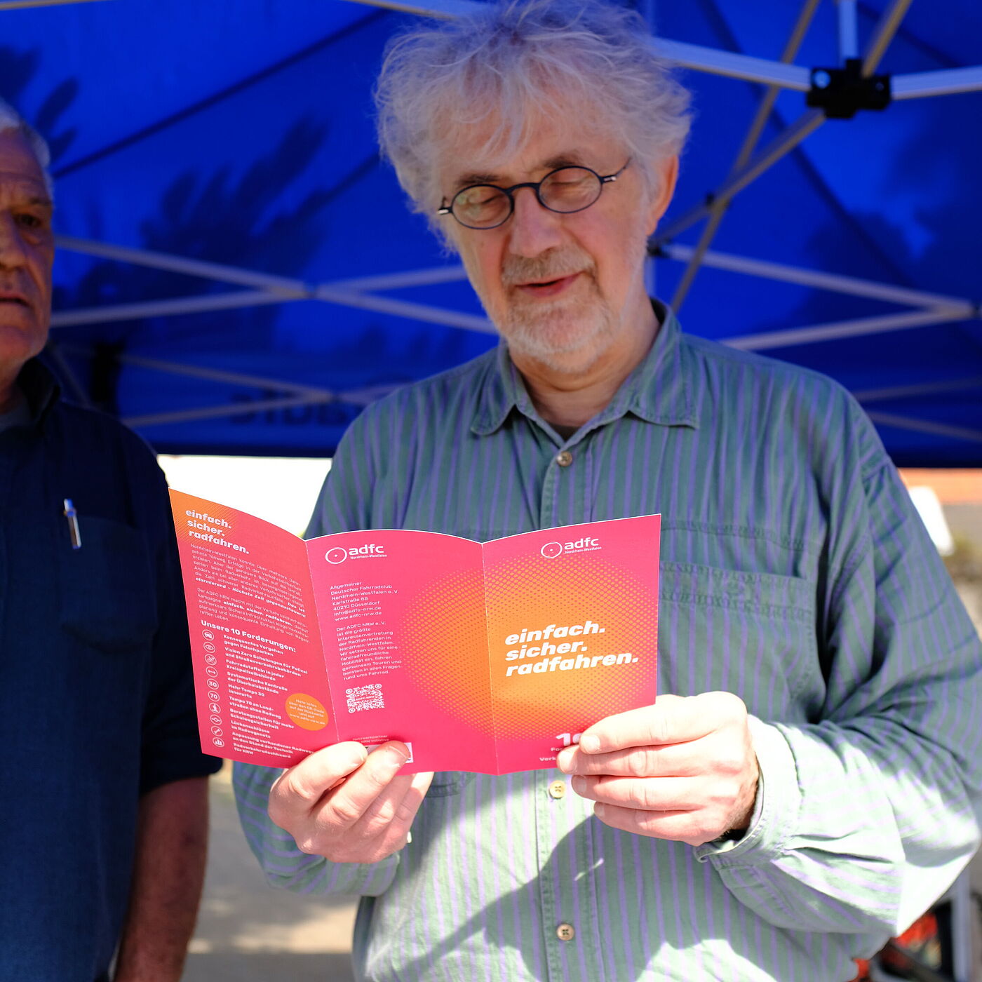 Eine Person hält einen Flyer in den Händen.